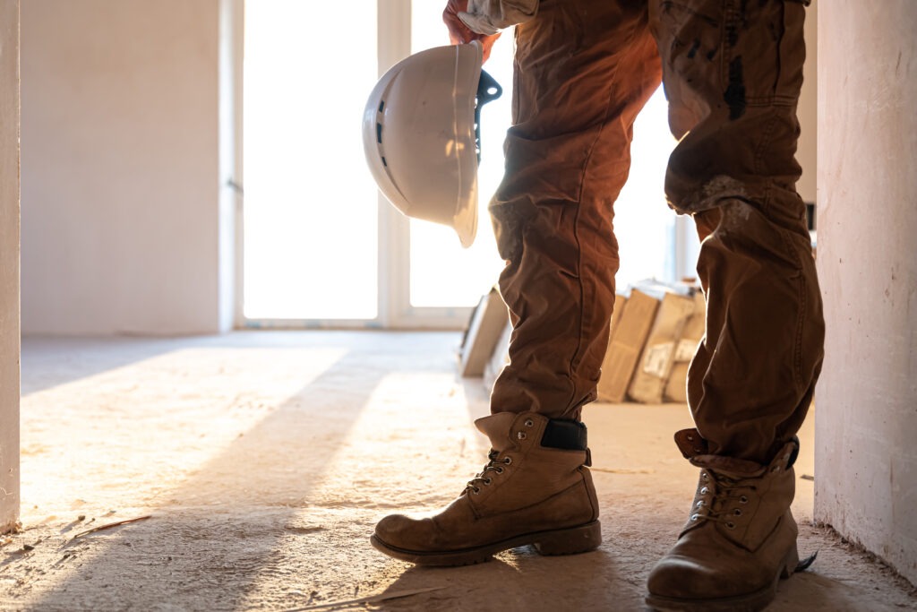 A man builder with a helmet in his hands, copy space.